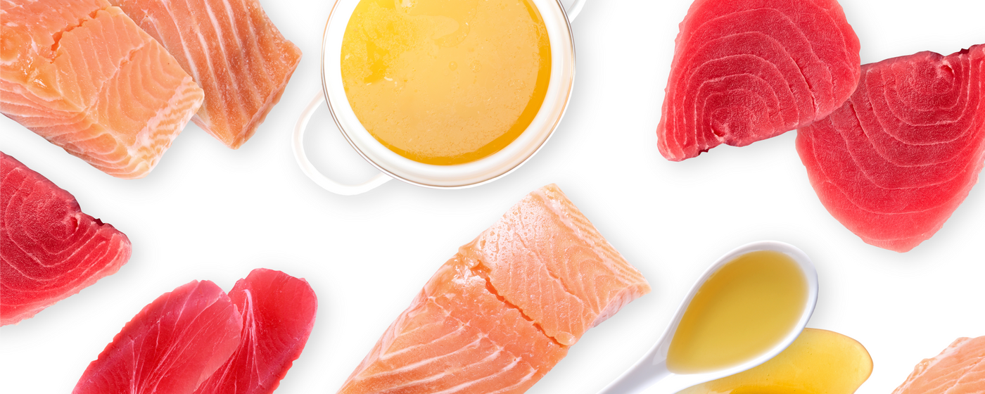Slices of raw salmon and tuna are arranged around a bowl and spoon of light yellow sauce on a white background.