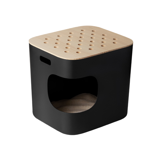 A modern, black, cube-shaped pet house with a rounded entrance, wooden top featuring circular holes, and a side handle; inside is a cushioned bed.