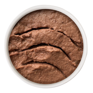 Top-down view of a round container filled with brown, textured Cat Person Tuna Juicy Paté cat food.