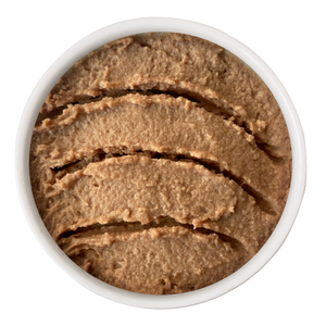 Top-down view of a small white bowl filled with smooth, textured Chicken & Duck Juicy Paté cat food.