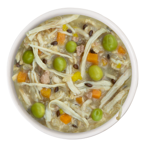 A bowl of Weruva Funky Chunky Recipe Plus dog food, made with white meat chicken, green peas, carrots, grains, and lentils in broth, shown from above on a white background.
