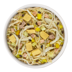A white bowl of Weruva Bed and Breakfast Recipe Plus shows a mixed dog meal with real white meat chicken, yellow cubes, diced veggies, brown beans, and grains for easy digestion. The bowl sits against a plain white background.