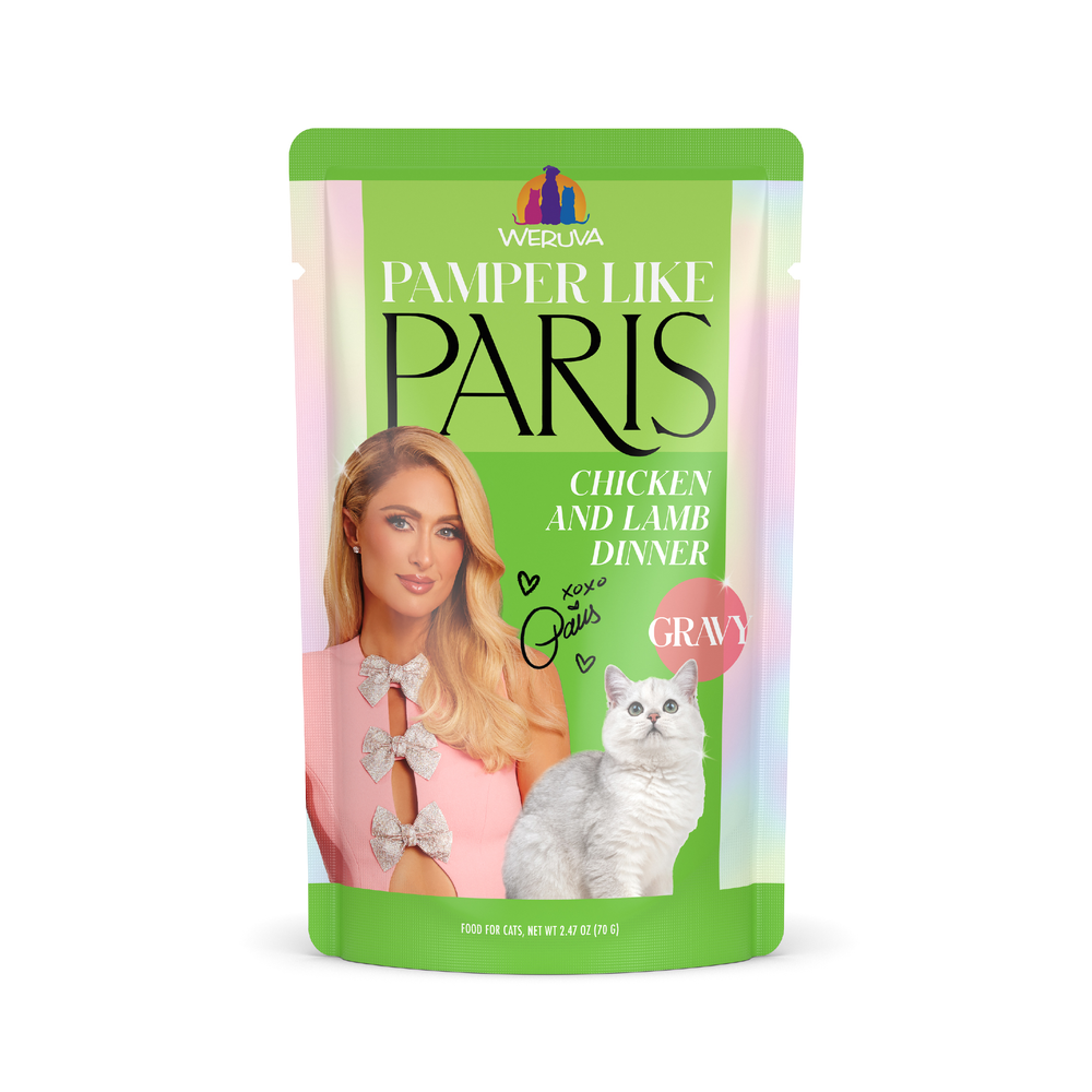 A pouch of Weruva Chicken and Lamb Dinner in Gravy cat food featuring a woman with blonde hair, a white cat, and pastel green and pink colors.