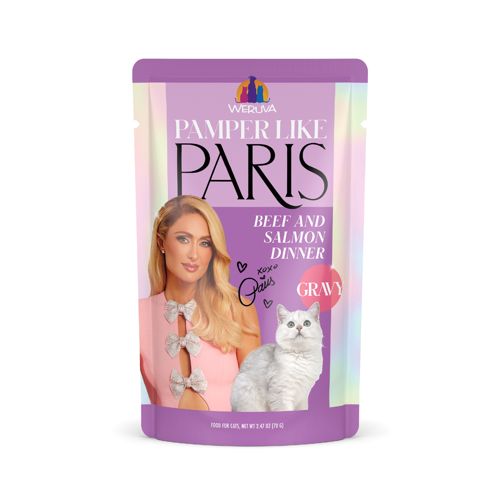 A pink and purple Weruva pouch labeled Beef and Salmon Dinner in Gravy features an illustrated woman in a pink dress, a gray and white cat, and highlights its grass-fed beef and wild-caught salmon ingredients.