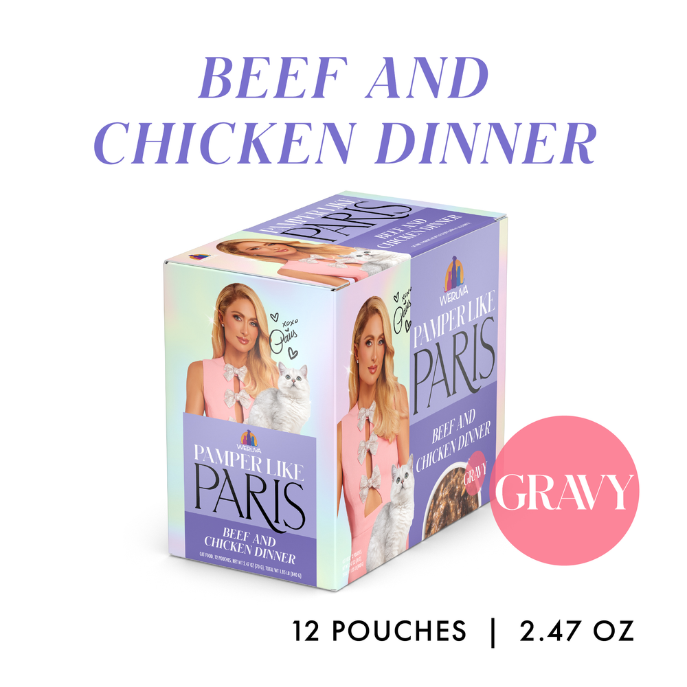 A box of Weruva Beef and Chicken Dinner in Gravy cat food, featuring 12 pouches made with grass-fed beef and cage-free chicken. The packaging shows a woman with long blonde hair holding a white cat and “Gravy” in a pink circle.