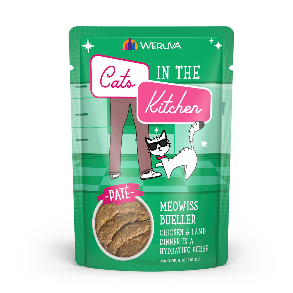 A green Cats in the Kitchen pouch labeled Meowiss Bueller, featuring cat paté made with cage-free chicken and grass-fed lamb, and showing a glasses-wearing cat beside a person's legs.