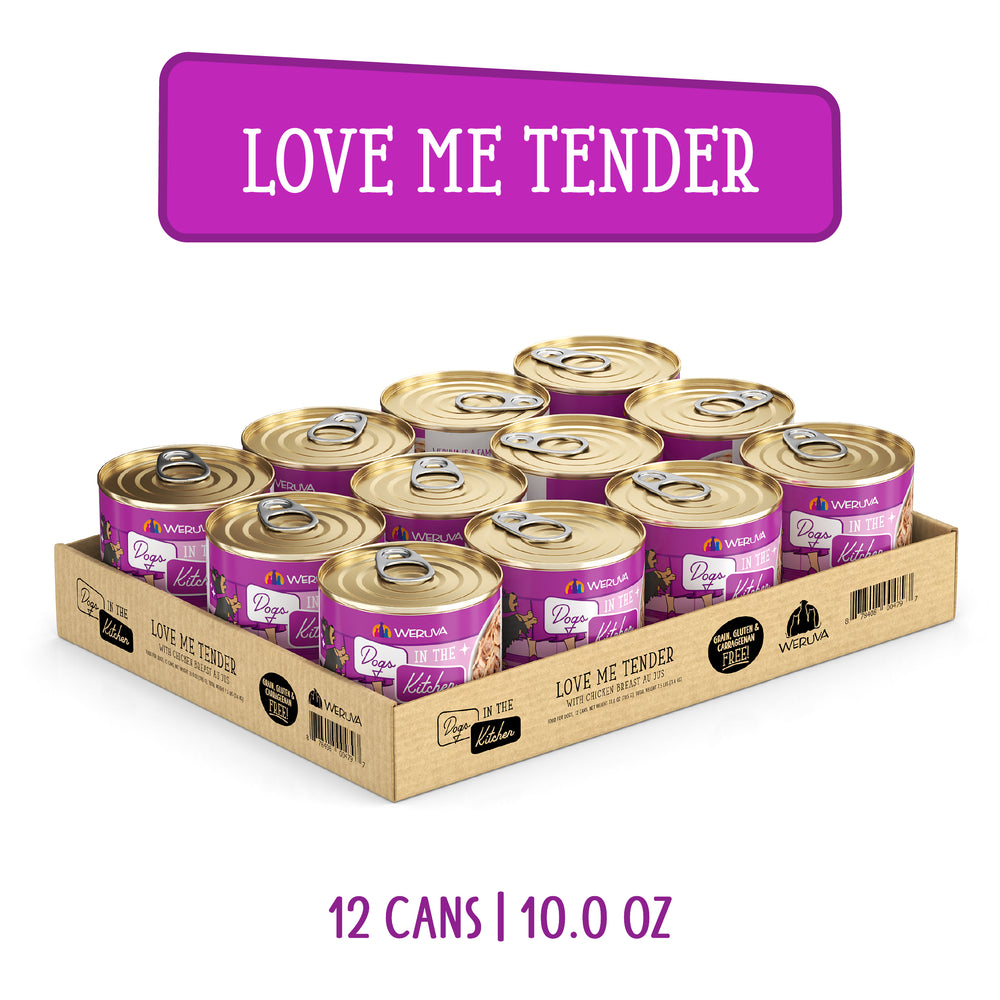 A cardboard tray holds 12 cans of Dogs in the Kitchen “Love Me Tender” cat food, each with a gold lid and purple label. Text above reads “LOVE ME TENDER”, below: “12 CANS | 10.0 OZ”. Made with cage-free chicken for premium meals.