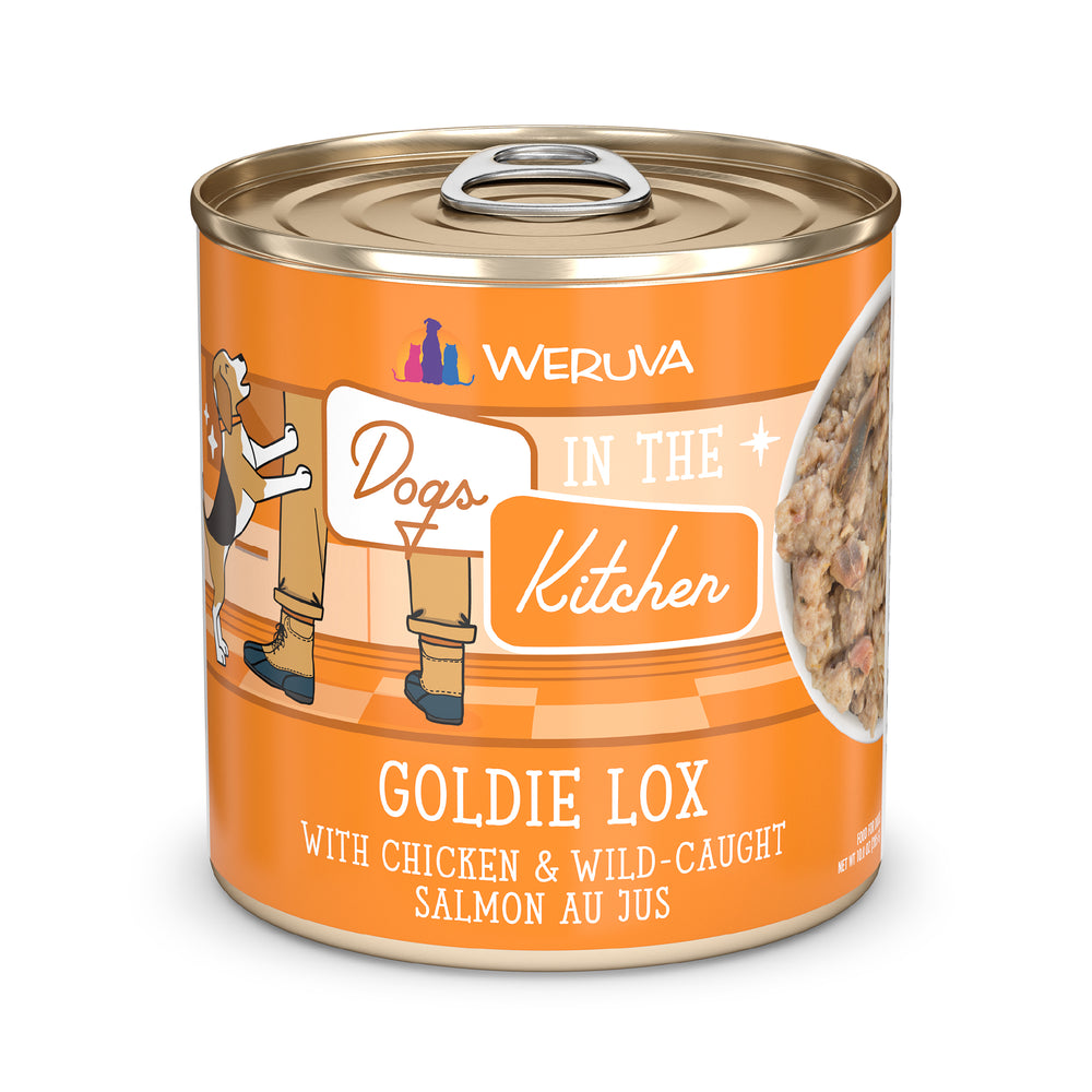 A can of Dogs in the Kitchen Goldie Lox dog food features protein-rich chicken and salmon au jus, with an orange label showing a cartoon dog and person by a kitchen counter.