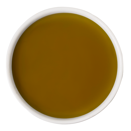 A white bowl of golden-yellow olive oil on a white background—a nourishing touch often added to dog wellness routines alongside Awesome Functions’ Awesome Everything Super Beef Bone Broth.