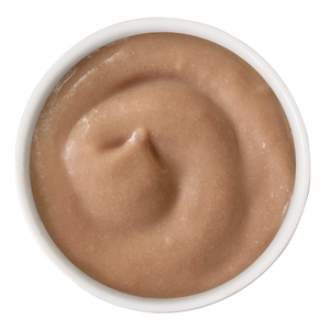 A white bowl of light brown bisque, viewed from above, shows a creamy swirled texture—just like the smooth consistency found in Cats in the Kitchen Chicken & Salmon Bisque with Senior Support for cats.