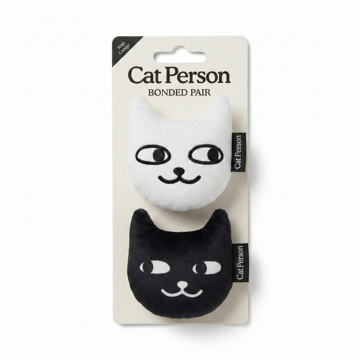 The Weruva Cat Person Bonded Pair Catnip Toy includes two plush cat toys, one white and one black, with embroidered faces and “Cat Person” tags—perfect for interactive play with your feline friend.
