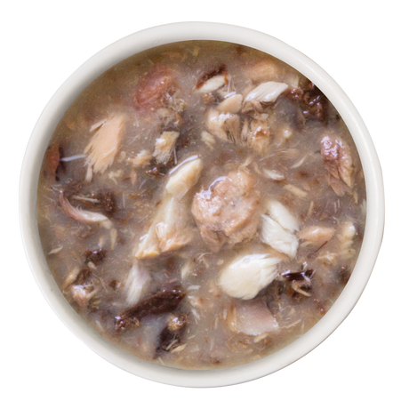 A white bowl filled with Weruva Salmon and Tuna Dinner in Gravy—chunky brownish soup with wild-caught salmon and meat—shown from above on a plain white background, a gourmet meal for discerning cats.