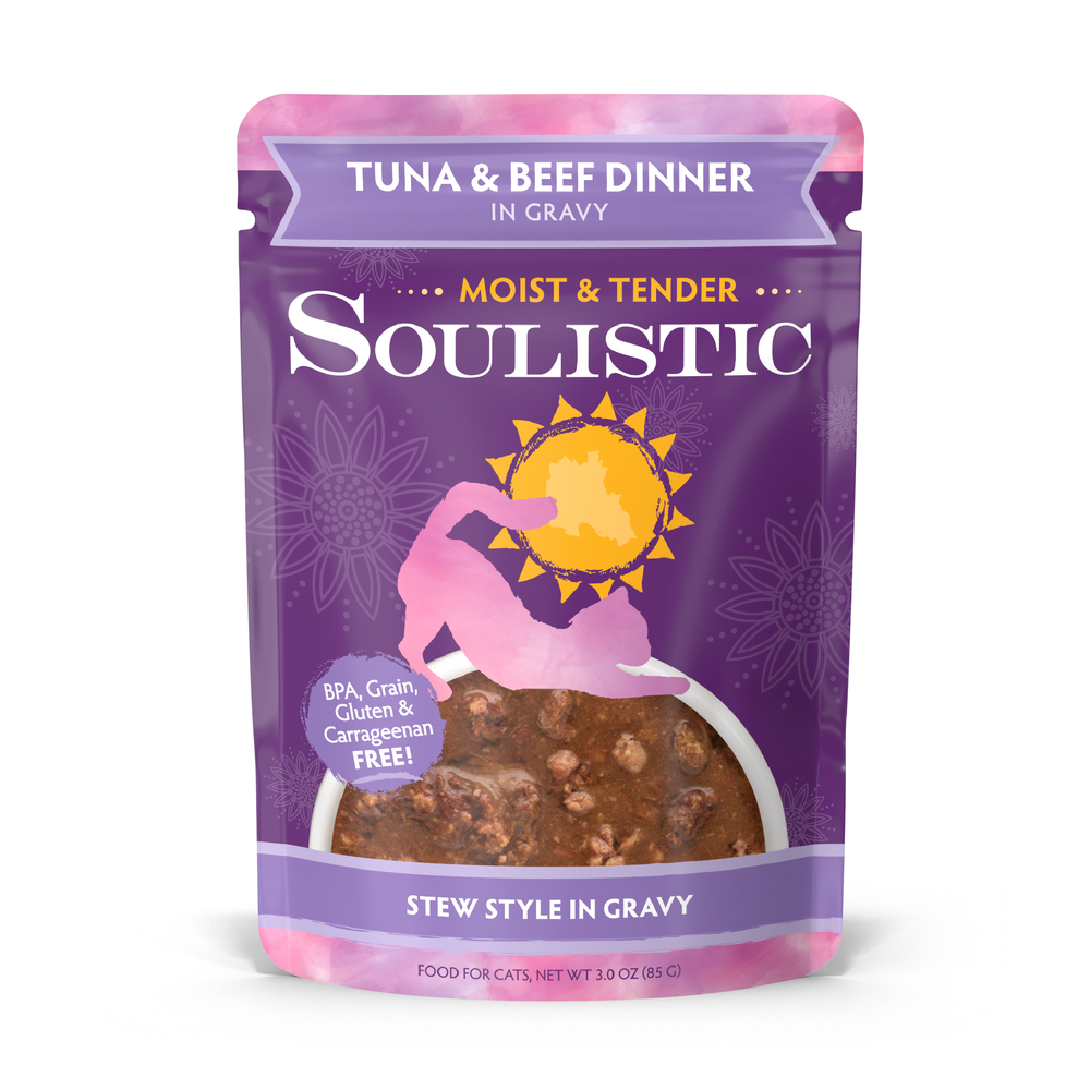 Soulistic Tuna & Beef Dinner in Gravy cat food comes in purple packaging with a cat silhouette, sun graphic, and window revealing stew-style food. Labels highlight wild-caught tuna and deboned beef as high-quality protein sources.