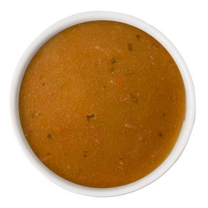 A white bowl of Dogs in the Kitchen Beef & Pumpkin Gravy Meal Topper, featuring smooth brown gravy with small veggie and herb pieces, viewed from above on a white background.