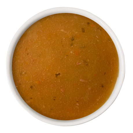 A white bowl of Dogs in the Kitchen Beef & Pumpkin Gravy Meal Topper, featuring smooth brown gravy with small veggie and herb pieces, viewed from above on a white background.