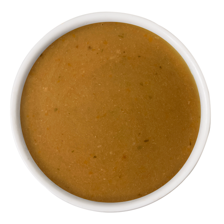 A white bowl filled with smooth, light brown Beef & Sweet Potato Gravy Meal Topper by Dogs in the Kitchen, viewed from above on a plain white background—the ideal finishing touch for your pup’s meal.