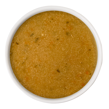 A white bowl filled with Dogs in the Kitchen Chicken & Sweet Potato Gravy Meal Topper, featuring light brown broth with bits of veggies and herbs, viewed from above on a white background—a perfect mealtime topper.