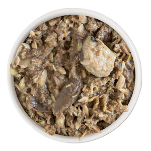 A white bowl filled with Soulistic Nautical Nirvana wet cat food, featuring wild-caught tuna chunks and flakes in a moist, gravy-like texture.