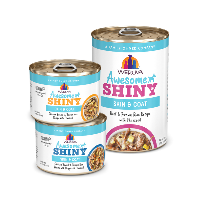 Three cans of Weruva Awesome Shiny Skin & Coat pet food are shown, featuring colorful labels. Two smaller cans are stacked on the left, and one larger can labeled “Beef & Brown Rice Recipe with Flaxseed” stands on the right.